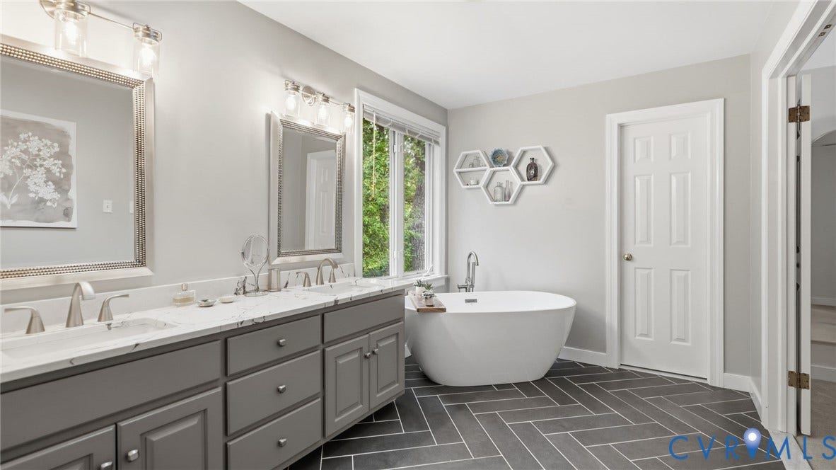 2040 Normandstone Drive, Roxshire, Midlothian, VA 23113 Dual-sink vanity with stone countertop and metallic fixtures, freestanding soaking tub, and herringbone-patterned tile flooring