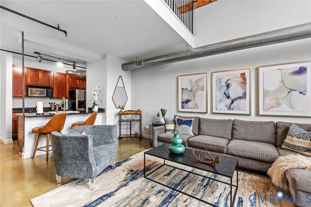 815 Porter Street, #U301, Richmond, VA 23224 Open-concept interior featuring high ceilings, exposed ductwork, polished concrete flooring, kitchen with built-in cabinetry, and integrated track lighting