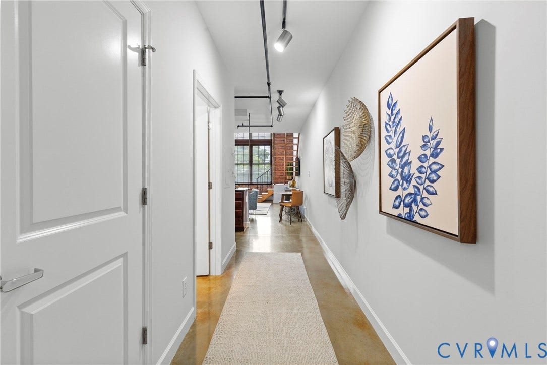 815 Porter Street, #U301, Richmond, VA 23224 Industrial-style hallway featuring polished concrete flooring, exposed overhead track lighting, and exposed brick structural elements