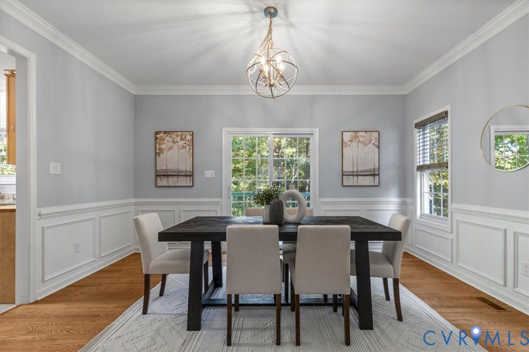 4011 Echo Ridge Place, Midlothian, VA 23112 Dining area featuring wood flooring, crown molding, decorative wainscoting, sliding glass doors, and chandelier