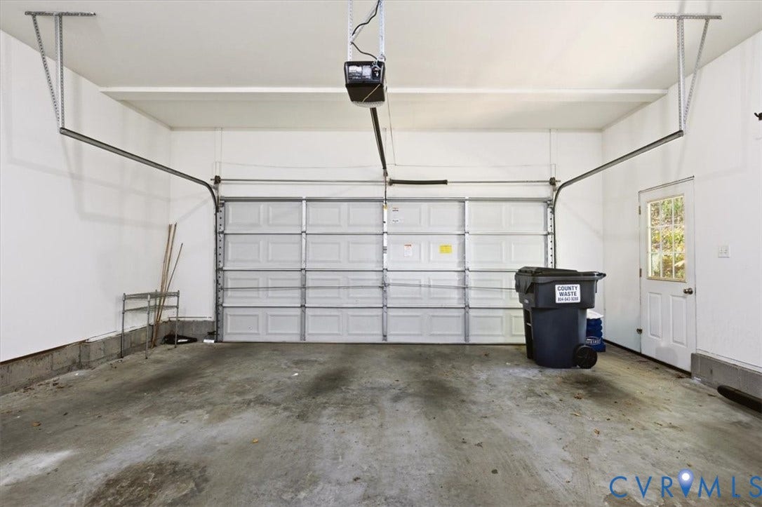4011 Echo Ridge Place, Midlothian, VA 23112 Multi-car garage featuring a sectional overhead door, automated garage door opener, concrete flooring, and an exterior access door with an inset window