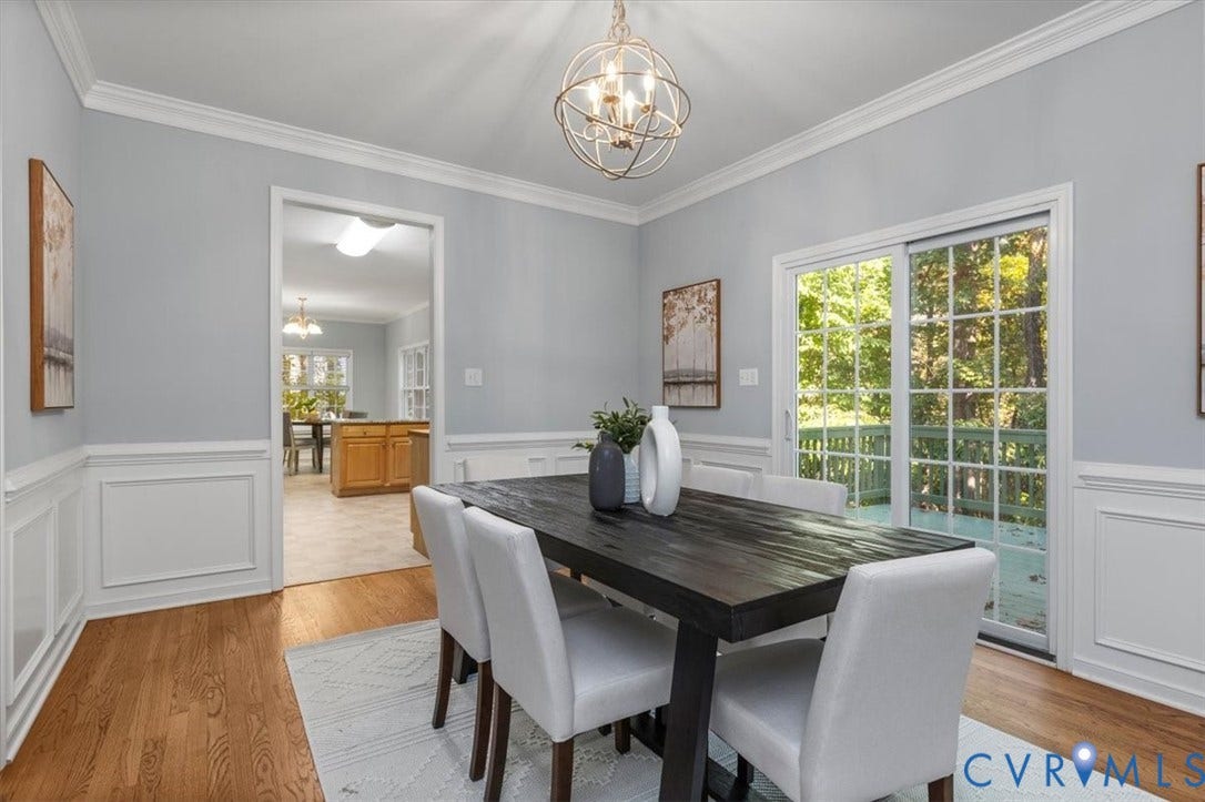 4011 Echo Ridge Place, Midlothian, VA 23112 Dining area featuring wood flooring, crown molding, decorative wainscoting, sliding glass doors, and chandelier