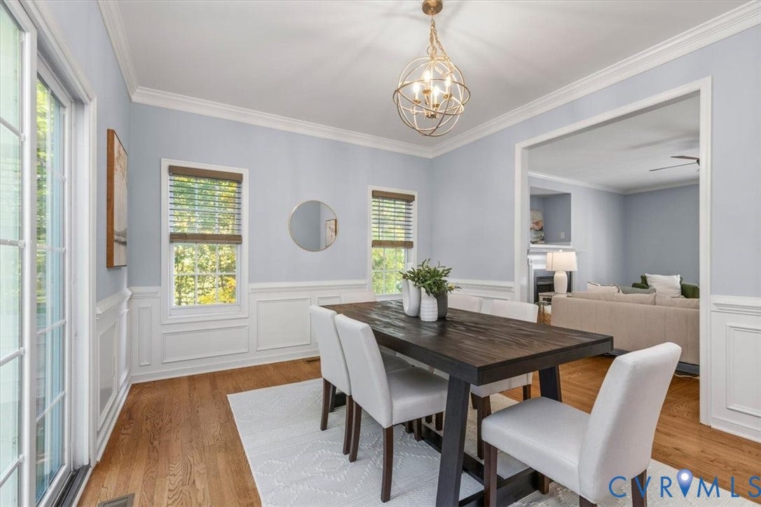 4011 Echo Ridge Place, Midlothian, VA 23112 Dining area featuring wood flooring, crown molding, decorative wainscoting, sliding glass doors, and chandelier
