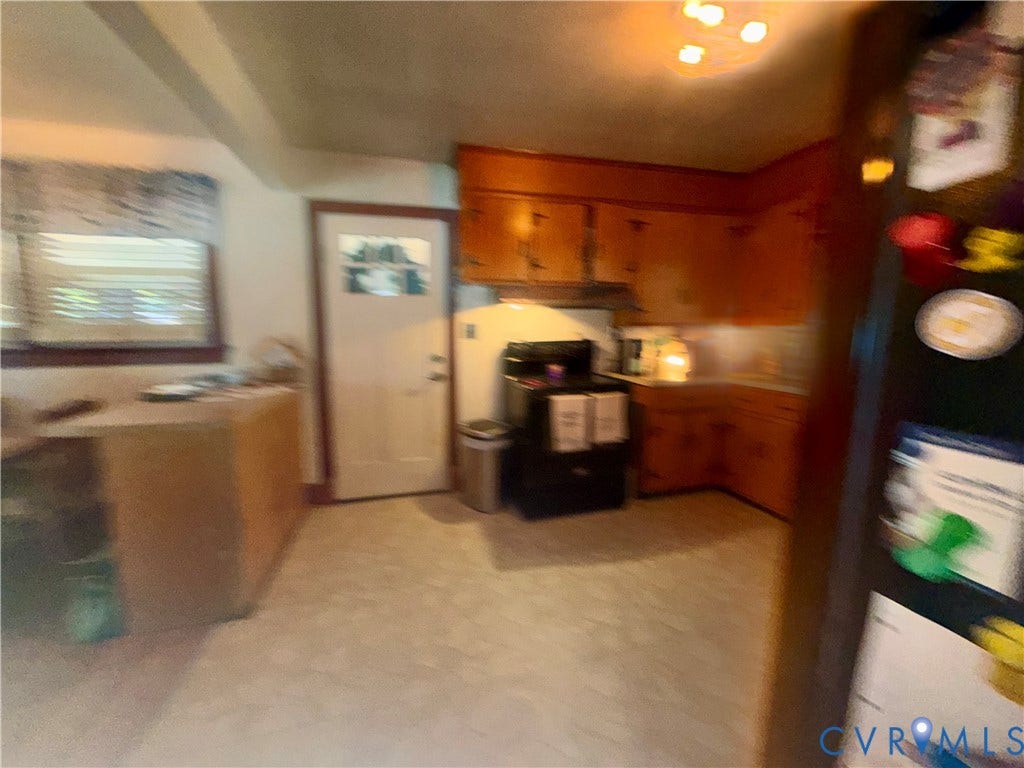 Kitchen featuring wooden cabinetry, solid-surface countertops, and a full-sized range
