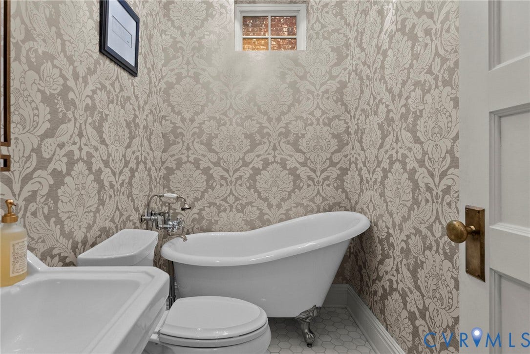 2416 Park Avenue, #U4, The Fan District, Richmond, VA 23220 Clawfoot soaking tub with metallic feet, patterned wallpaper, wall-mounted faucet, hexagon tile flooring, and multi-pane window