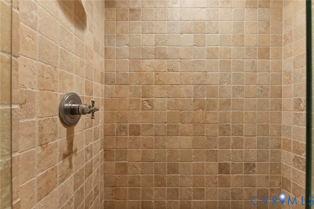 2416 Park Avenue, #U4, The Fan District, Richmond, VA 23220 Shower enclosure featuring floor-to-ceiling square stone-finish tiles and a brushed metallic cross-handle pressure balance valve