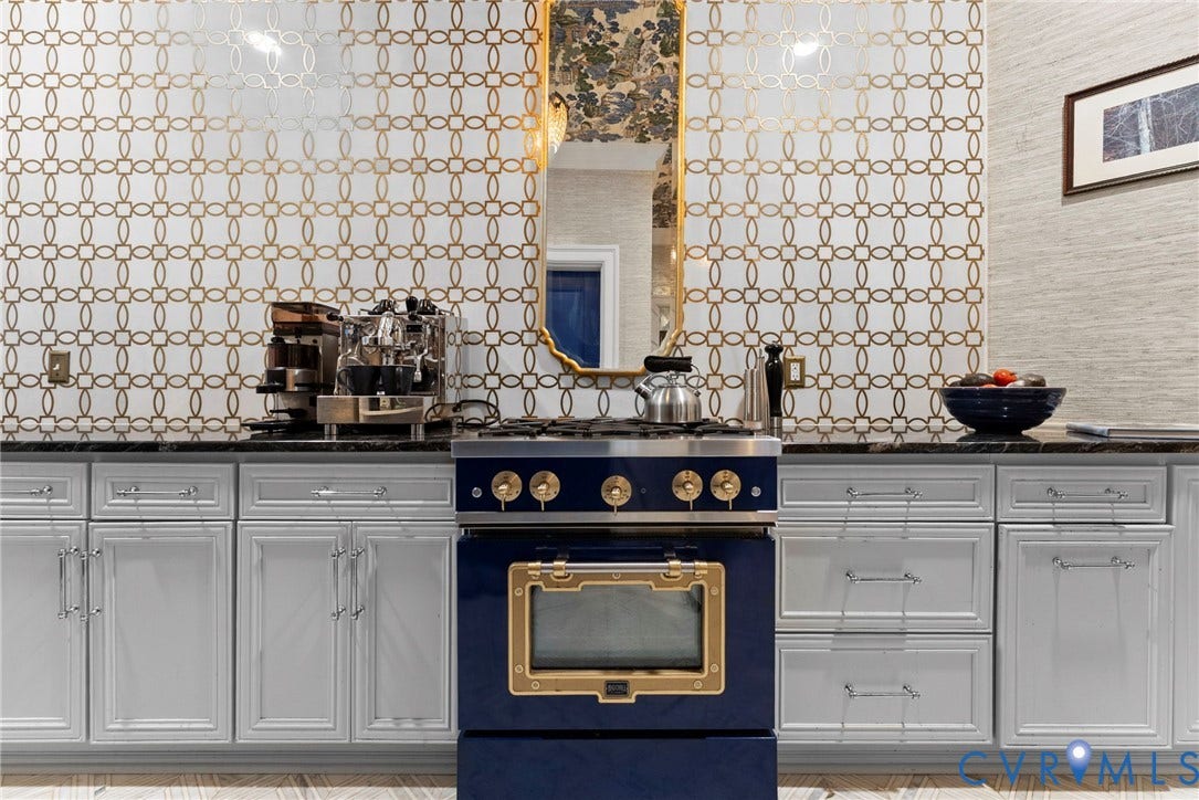 2416 Park Avenue, #U4, The Fan District, Richmond, VA 23220 Custom cabinetry with shaker-style doors, metallic geometric wall tile, stone countertop, and navy blue range with gold-tone hardware