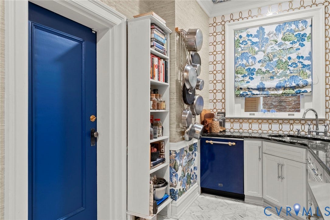 2416 Park Avenue, #U4, The Fan District, Richmond, VA 23220 Custom-built narrow shelving unit, patterned wall covering, blue-finished dishwasher, dark stone-finish countertop, and white cabinetry with metal hardware