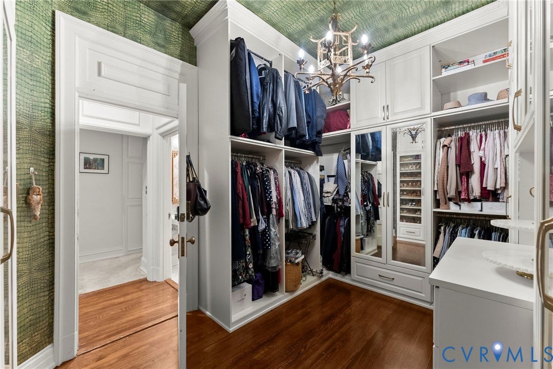 2416 Park Avenue, #U4, The Fan District, Richmond, VA 23220 Walk-in closet featuring custom floor-to-ceiling white cabinetry, mirrored wardrobe doors, integrated shelving, hardwood flooring, and a decorative chandelier