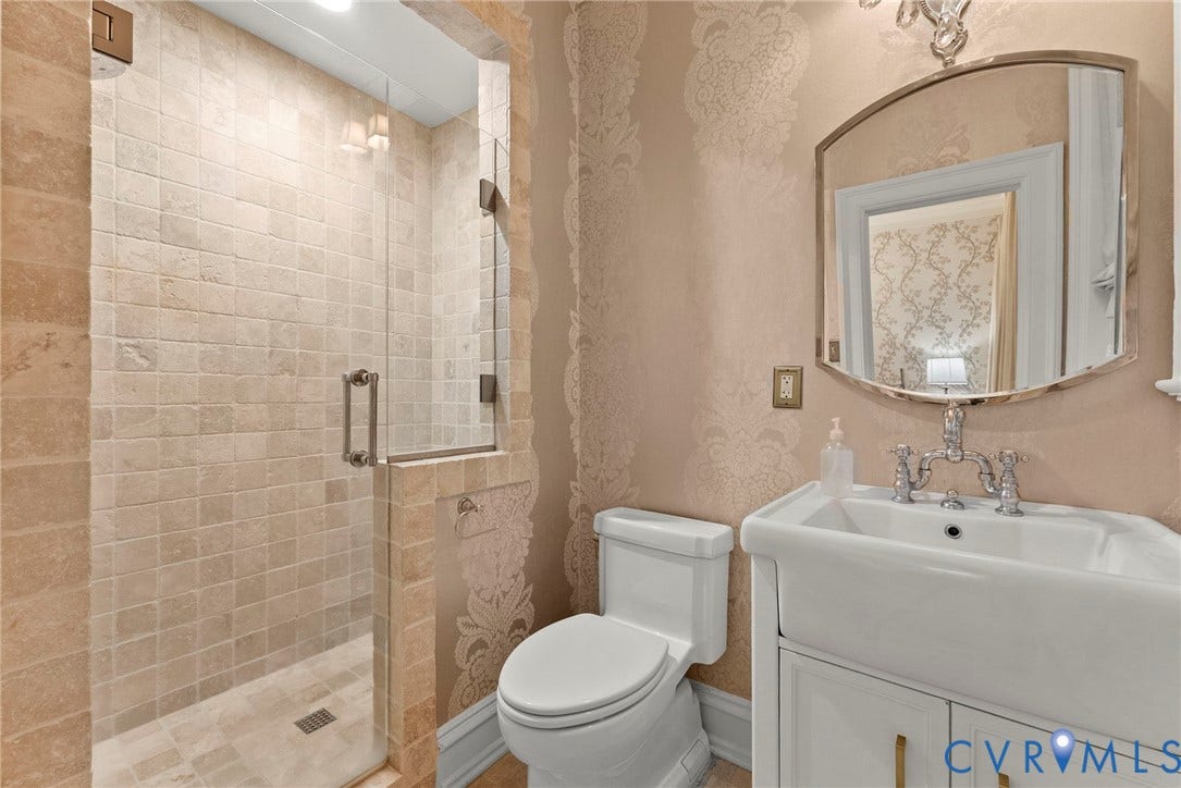 2416 Park Avenue, #U4, The Fan District, Richmond, VA 23220 Walk-in shower with natural stone tiling and glass enclosure, porcelain pedestal sink with polished metal bridge faucet, and ornate wall-mounted mirror