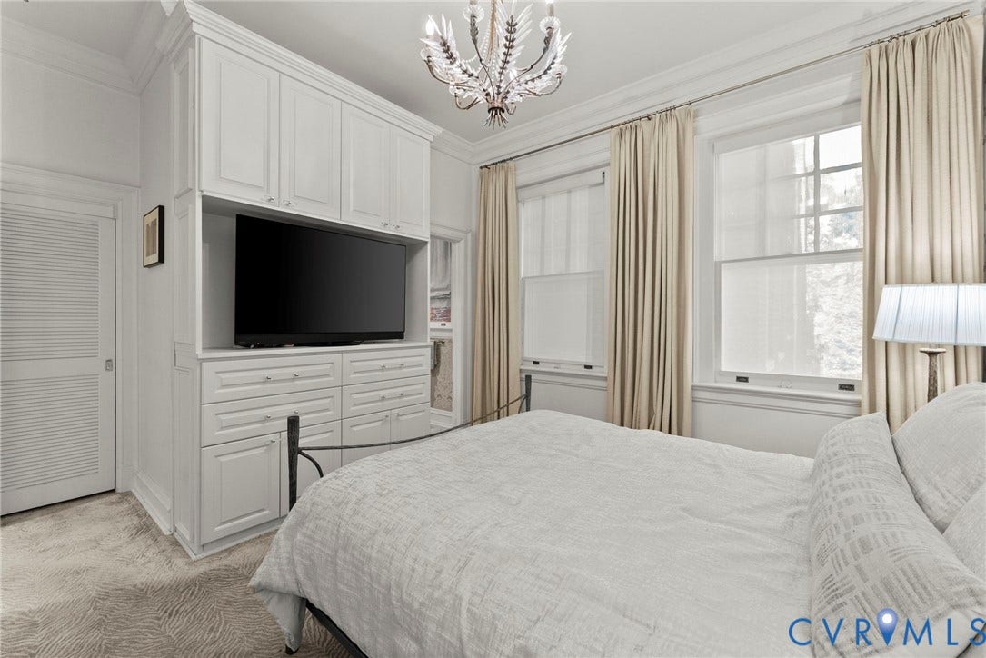 2416 Park Avenue, #U4, The Fan District, Richmond, VA 23220 Custom floor-to-ceiling built-in cabinetry, ornate ceiling chandelier, crown molding, double-hung windows, and louvered door