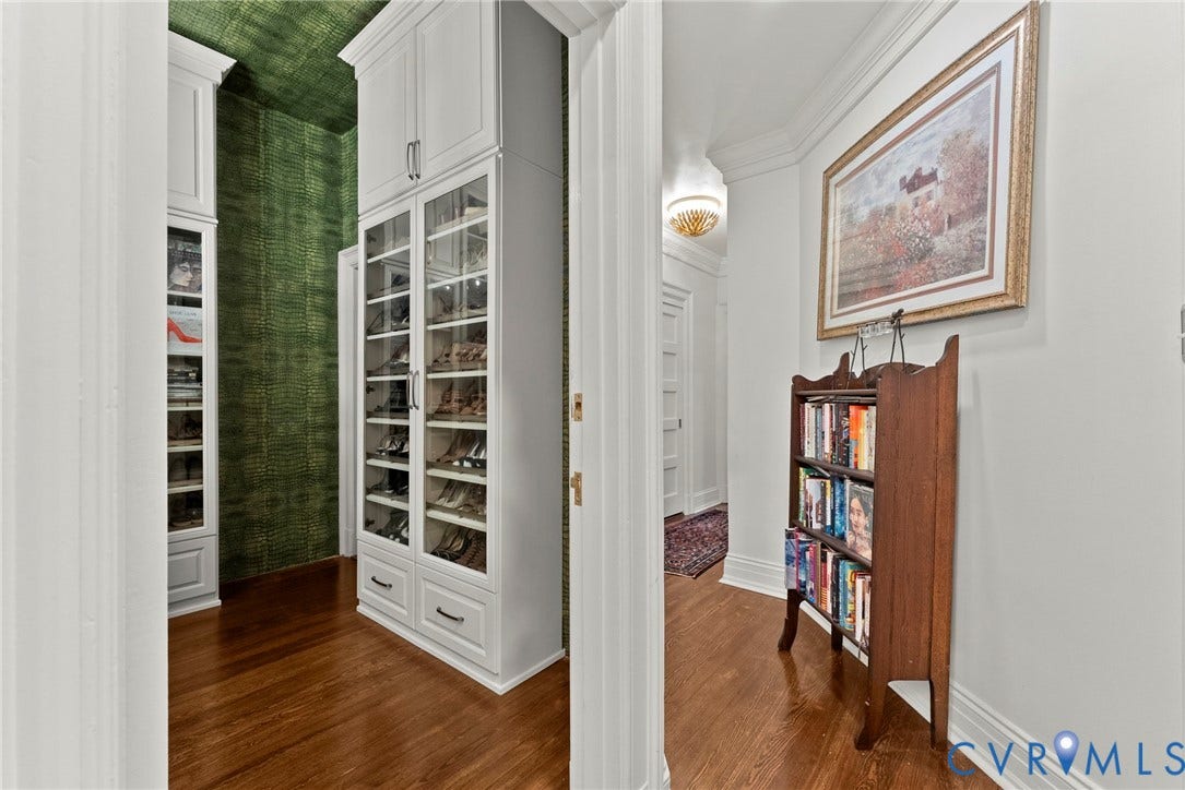 2416 Park Avenue, #U4, The Fan District, Richmond, VA 23220 Custom white floor-to-ceiling cabinetry with glass-panel doors, integrated shelving, and dark-toned hardware, featuring wood-finish flooring and patterned wall coverings