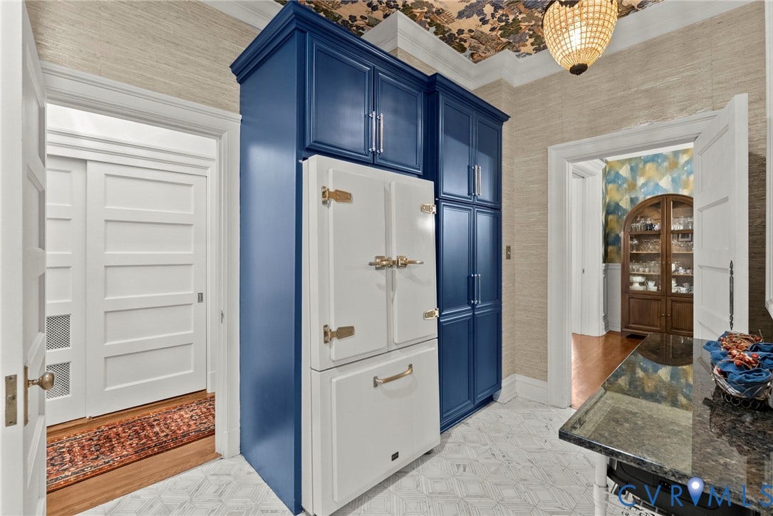 2416 Park Avenue, #U4, The Fan District, Richmond, VA 23220 Custom floor-to-ceiling blue cabinetry with integrated paneled refrigerator, patterned ceiling wallpaper, natural fiber wall covering, and stone tile flooring