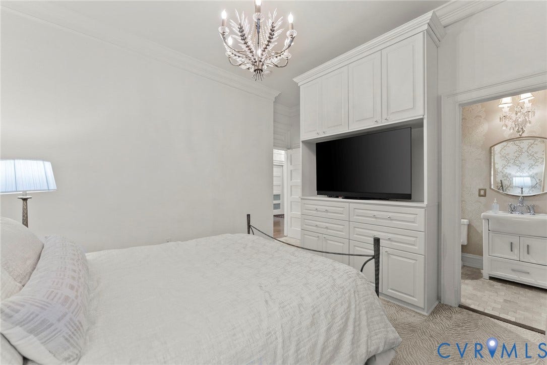 2416 Park Avenue, #U4, The Fan District, Richmond, VA 23220 Built-in floor-to-ceiling cabinetry with integrated storage and media niche, multi-arm crystal chandelier, and crown molding