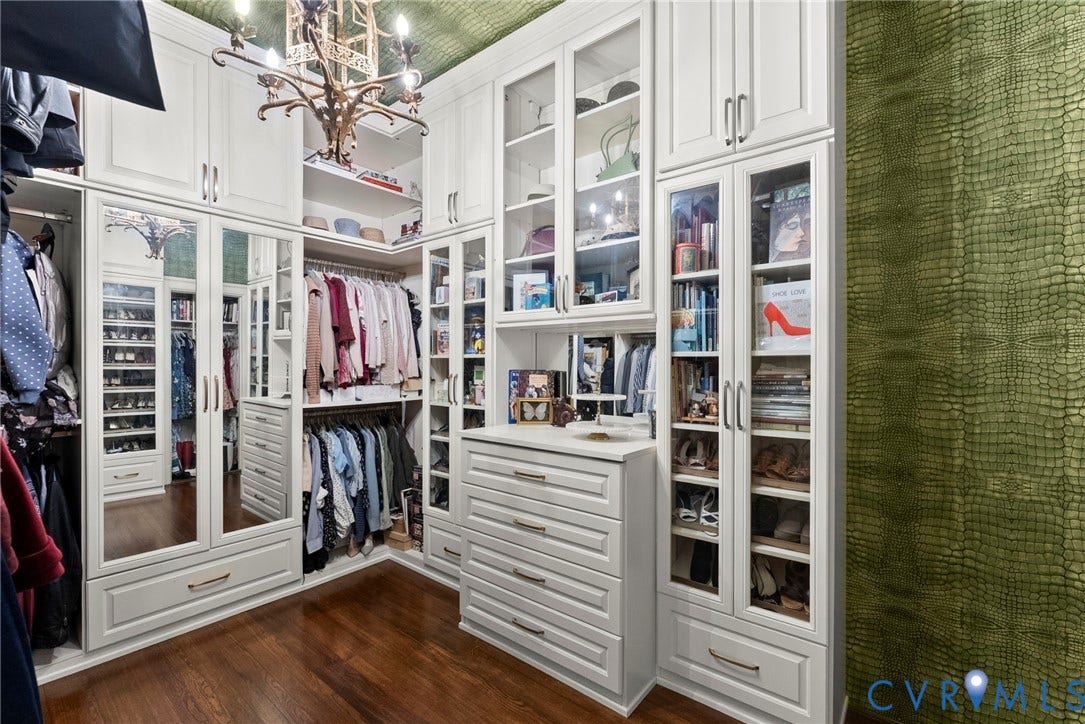 2416 Park Avenue, #U4, The Fan District, Richmond, VA 23220 Custom floor-to-ceiling cabinetry with glass-front display doors, integrated drawer storage, mirrored door panels, wood-finish flooring, and ornate metal chandelier