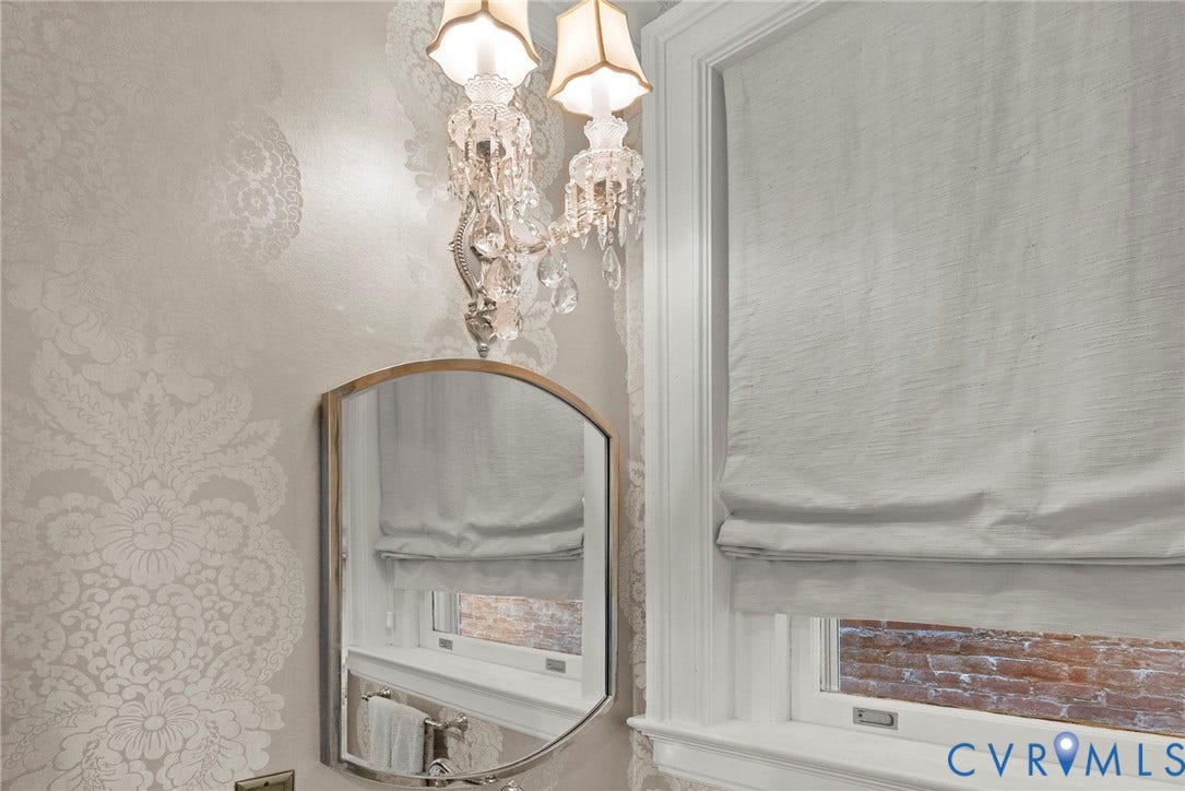 2416 Park Avenue, #U4, The Fan District, Richmond, VA 23220 Crystal-accented double wall sconce, ornate damask-patterned wallcovering, arched metal-framed mirror, and custom window casing with integrated sill