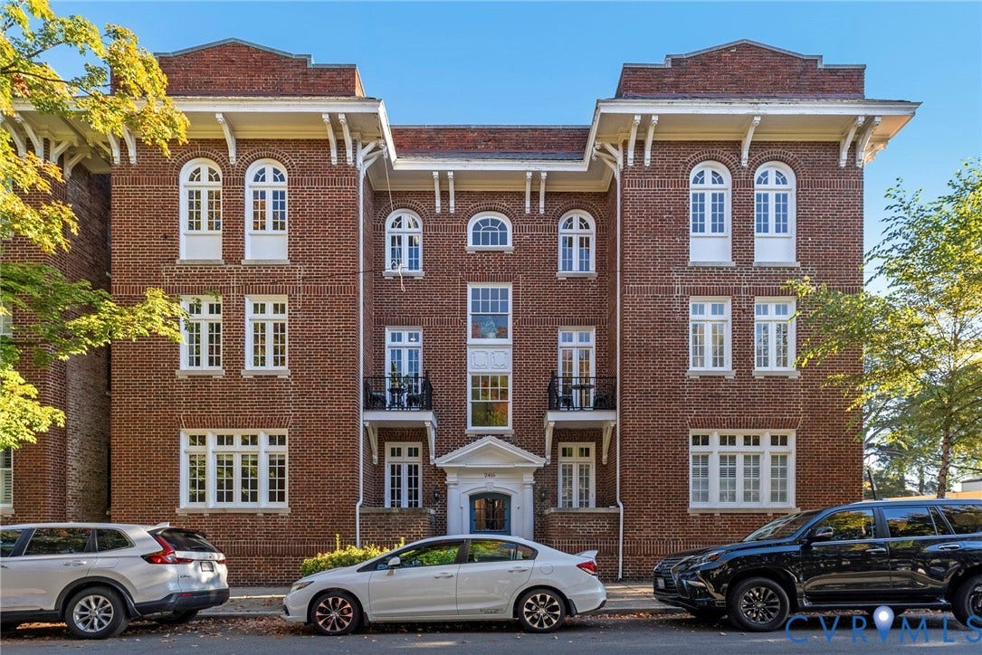 2416 Park Avenue, #U4, The Fan District, Richmond, VA 23220 Brick facade exterior featuring arched window detailing, overhanging eaves with decorative brackets, two wrought-iron balconies, and a formal entryway pediment