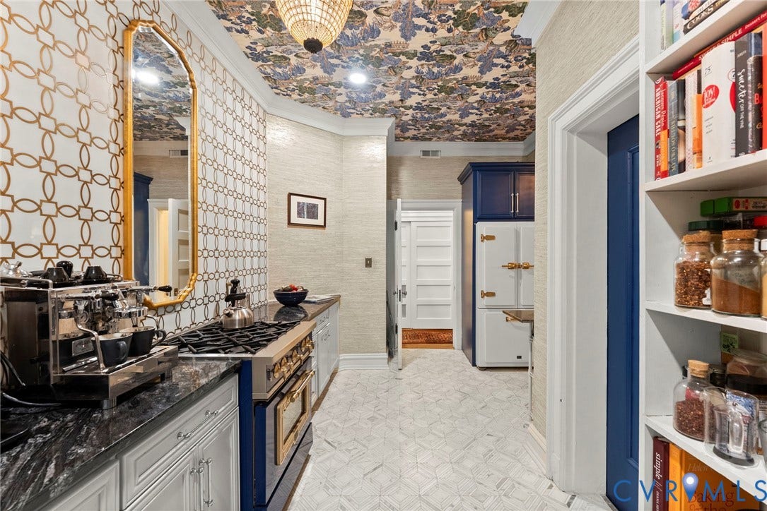 2416 Park Avenue, #U4, The Fan District, Richmond, VA 23220 Patterned wallpaper ceiling, custom blue cabinetry with metallic hardware, geometric tile backsplash, stone countertop, and built-in shelving