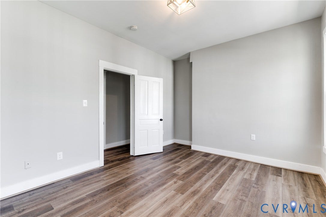 620 Chimborazo Boulevard, Church Hill, Richmond, VA 23223 Room featuring wood-finish flooring, neutral walls, a white four-panel door, and a geometric flush-mount light fixture