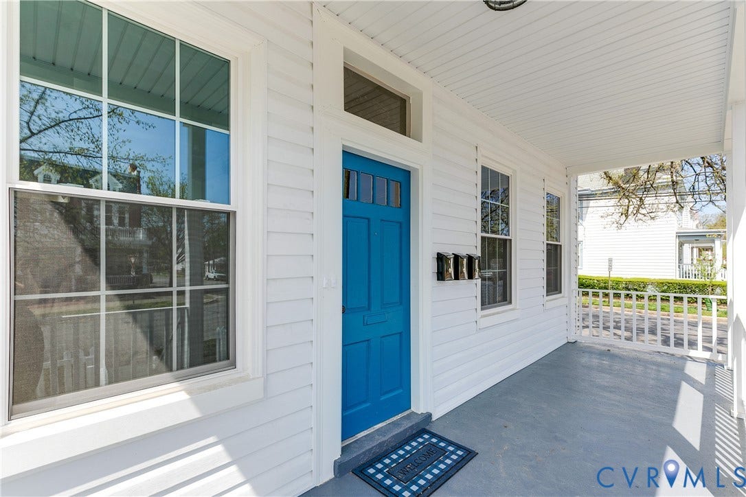 620 Chimborazo Boulevard, Church Hill, Richmond, VA 23223 Covered front porch featuring white horizontal siding, a solid entry door with transom window, and multi-pane windows with grid detailing