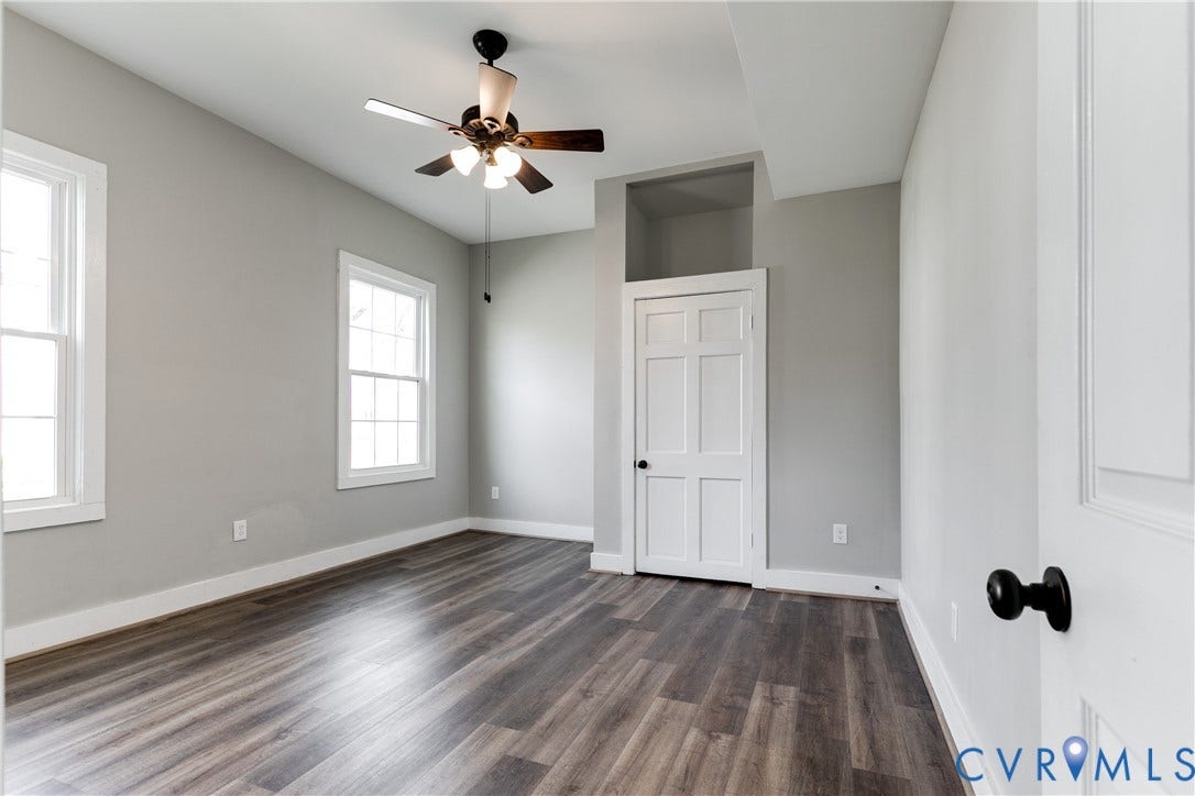 620 Chimborazo Boulevard, Church Hill, Richmond, VA 23223 Room featuring wood-finish flooring, neutral wall paint, multi-pane windows, a six-panel door with matte black hardware, and an overhead ceiling fan with integrated lighting