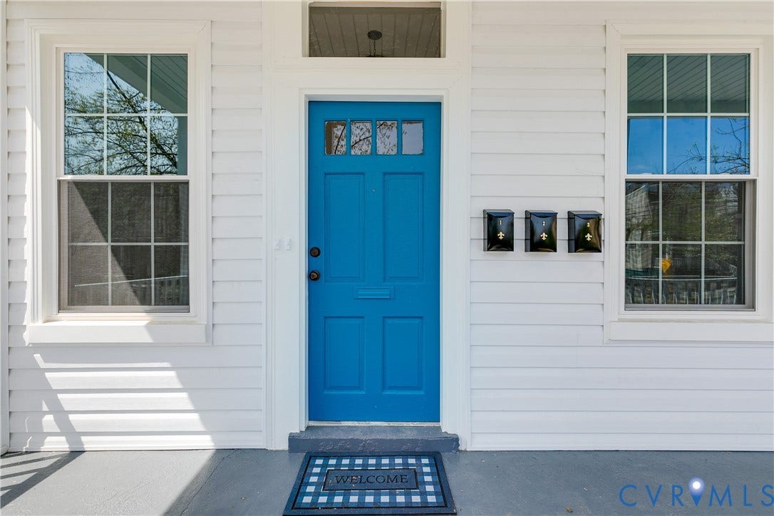 620 Chimborazo Boulevard, Church Hill, Richmond, VA 23223 Exterior entrance featuring horizontal lap siding, a vibrant blue entry door with a multi-pane transom window, and symmetrical multi-pane windows