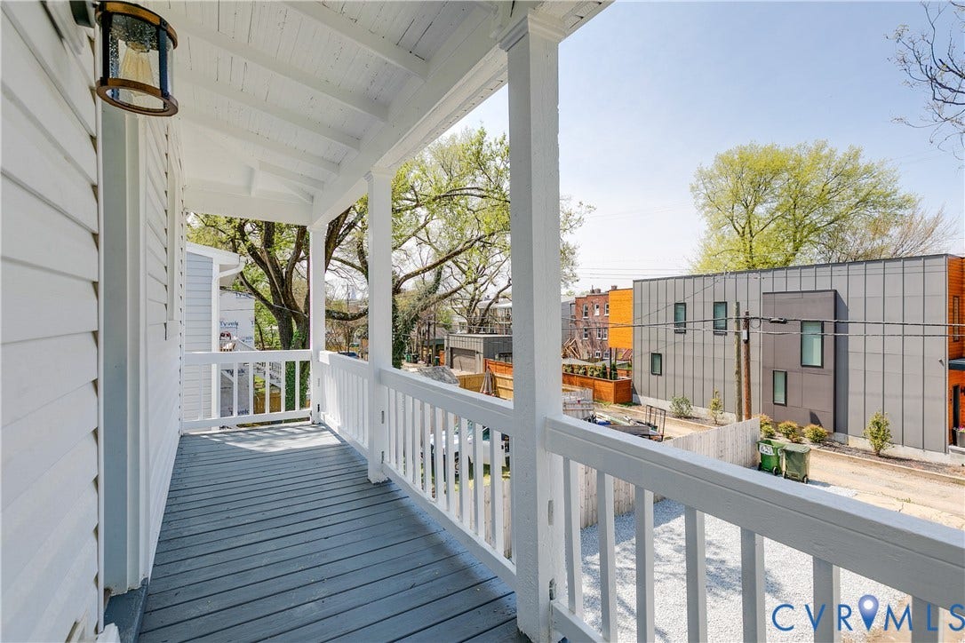 620 Chimborazo Boulevard, Church Hill, Richmond, VA 23223 Covered porch featuring wood-finish decking, white railings, structural support columns, and an exterior wall-mounted light fixture