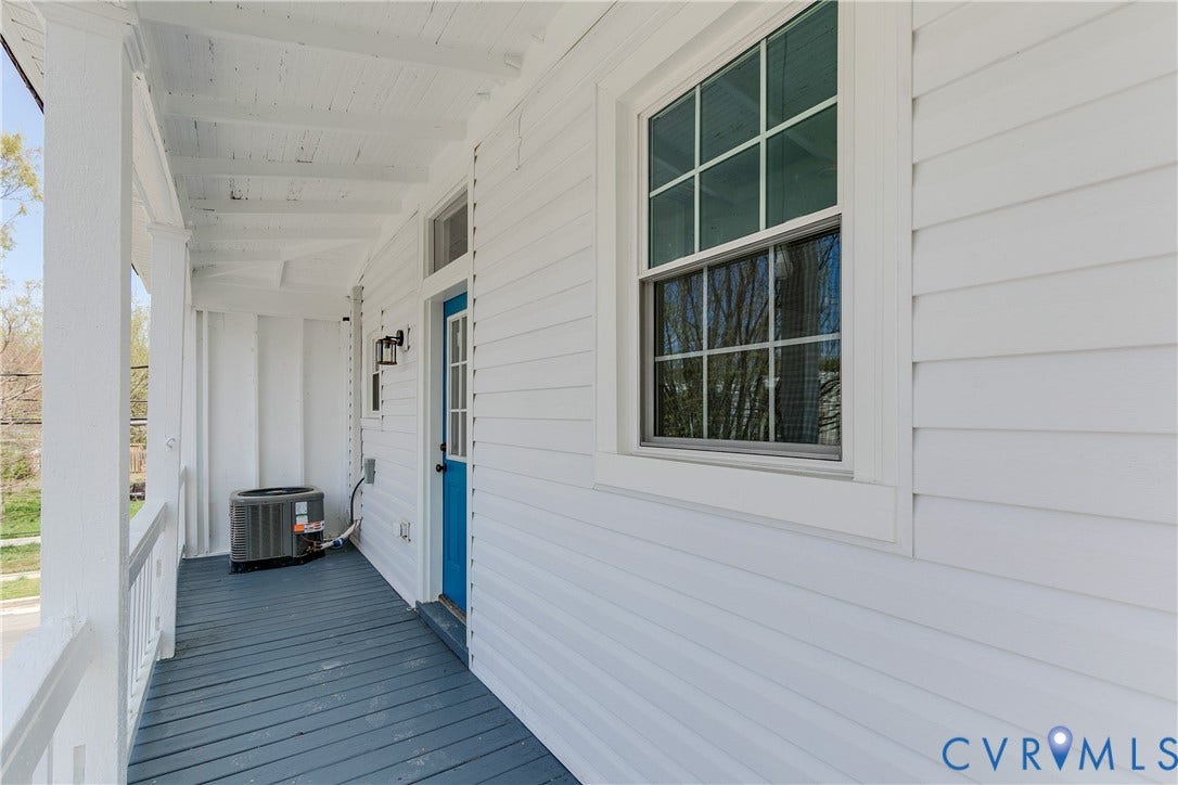 620 Chimborazo Boulevard, Church Hill, Richmond, VA 23223 Covered porch featuring white horizontal siding, painted wood-plank flooring, a grid-pattern window, and a paneled entry door with a transom window