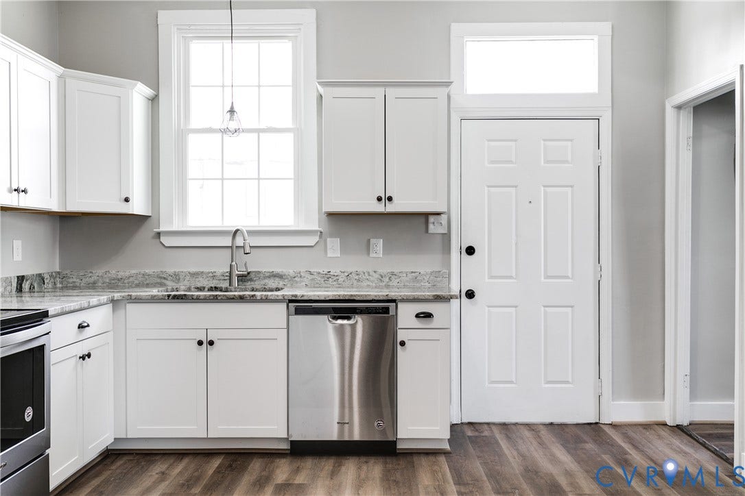 620 Chimborazo Boulevard, Church Hill, Richmond, VA 23223 White shaker-style cabinetry, stone-patterned countertops, stainless steel dishwasher, wood-finish flooring, and a transom window above the entry door