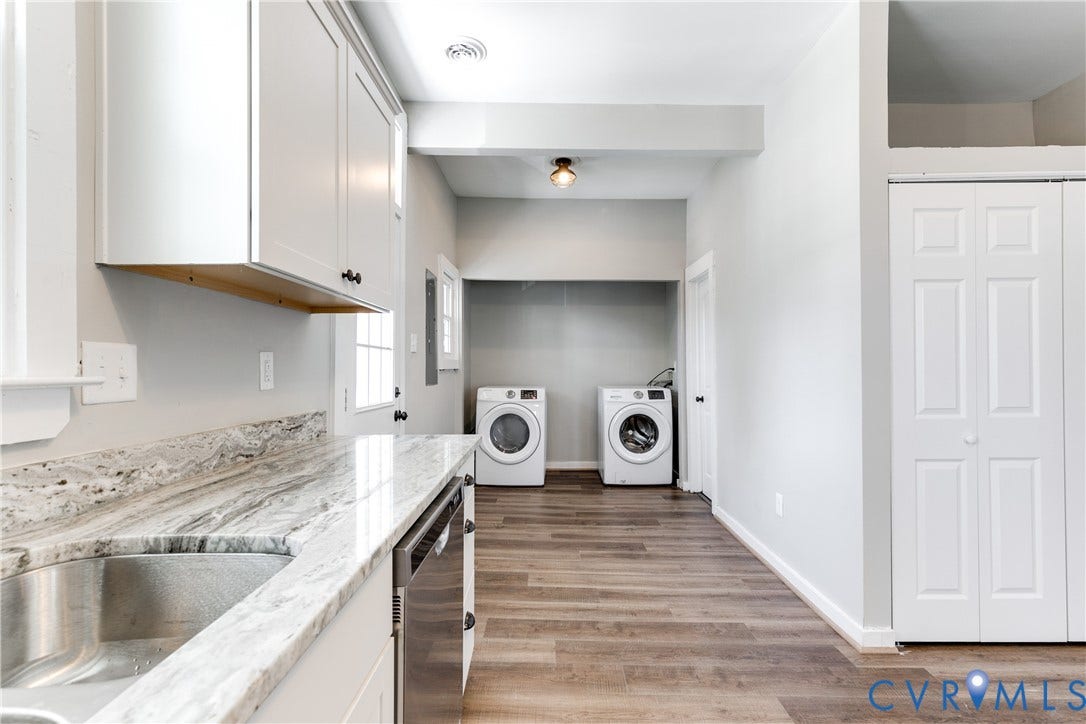 620 Chimborazo Boulevard, Church Hill, Richmond, VA 23223 Laundry area featuring wood-finish flooring, white shaker-style cabinetry, natural stone-patterned countertops, a stainless steel undermount sink, and bi-fold closet doors