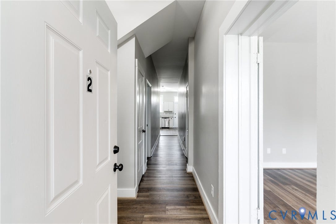 620 Chimborazo Boulevard, Church Hill, Richmond, VA 23223 Interior hallway featuring wood-finish flooring, crisp neutral wall paint, and multiple interior doors with matte black hardware
