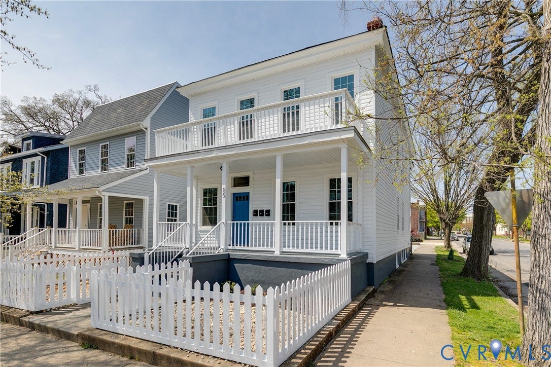 620 Chimborazo Boulevard, Church Hill, Richmond, VA 23223 Two-story residence featuring horizontal lap siding, an expansive full-width front porch, a second-story balcony with white balustrades, and a white picket fence enclosing the front yard