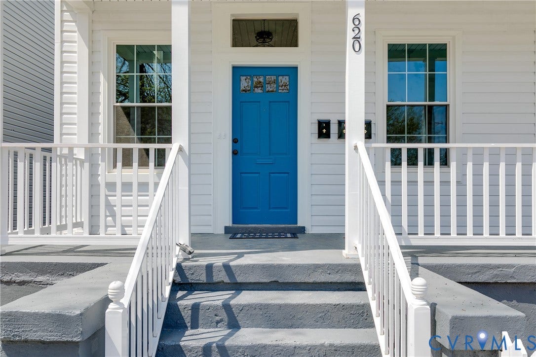 620 Chimborazo Boulevard, Church Hill, Richmond, VA 23223 Covered front porch featuring white railings, gray concrete steps, lap siding, and a blue paneled front door with a transom window