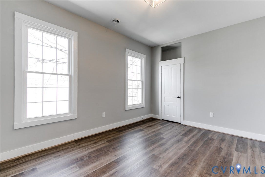 620 Chimborazo Boulevard, Church Hill, Richmond, VA 23223 Interior room featuring wood-finish flooring, two multi-pane windows, and a single-panel door with an integrated transom