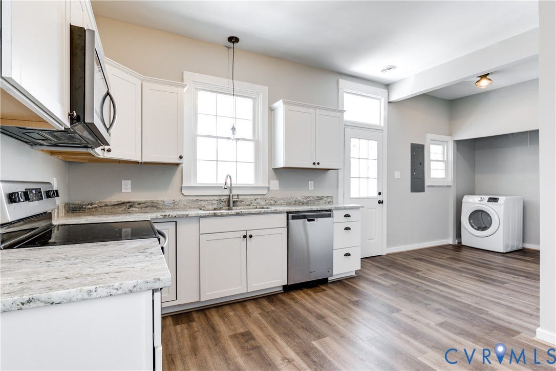 620 Chimborazo Boulevard, Church Hill, Richmond, VA 23223 Kitchen featuring white cabinetry, light-toned stone-finish countertops, stainless steel appliances, wood-finish flooring, and a dedicated laundry area