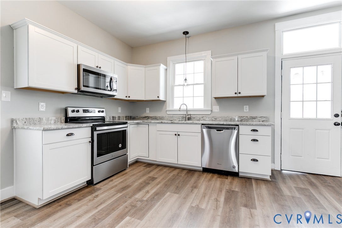 620 Chimborazo Boulevard, Church Hill, Richmond, VA 23223 Kitchen featuring white cabinetry, stone-surface countertops, stainless steel appliances, wood-finish flooring, and a single-light exterior door with a transom window