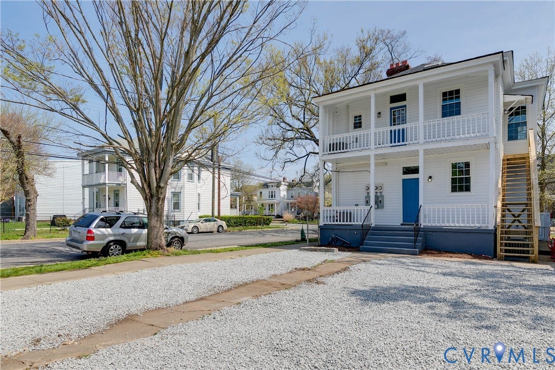 620 Chimborazo Boulevard, Church Hill, Richmond, VA 23223 Two-story exterior with white lap siding, dual-level covered porches, external wooden staircase, and a dedicated gravel parking area