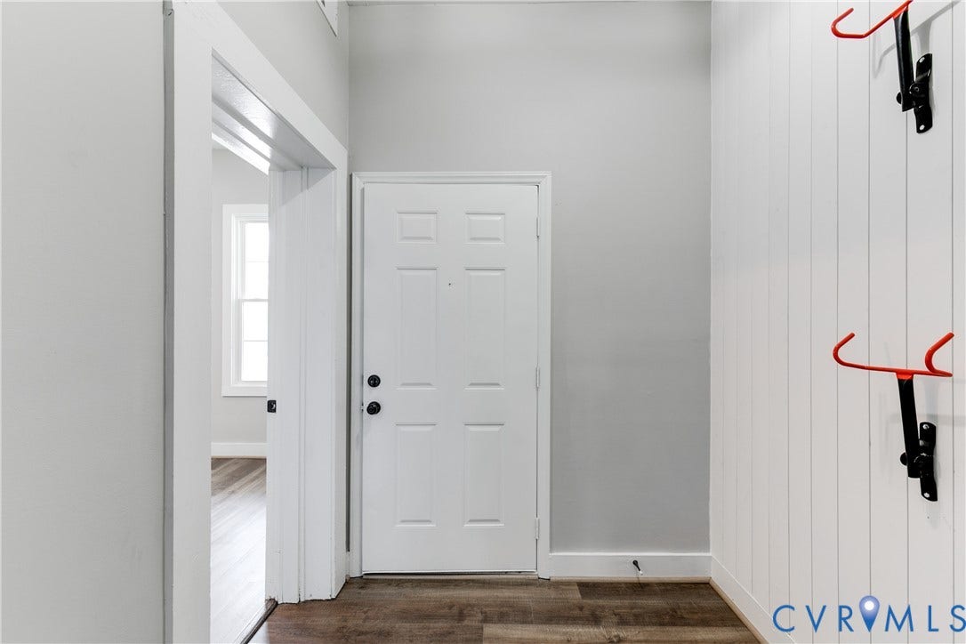620 Chimborazo Boulevard, Church Hill, Richmond, VA 23223 Entryway featuring wood-finish flooring, white vertical plank wall paneling, and a six-panel door