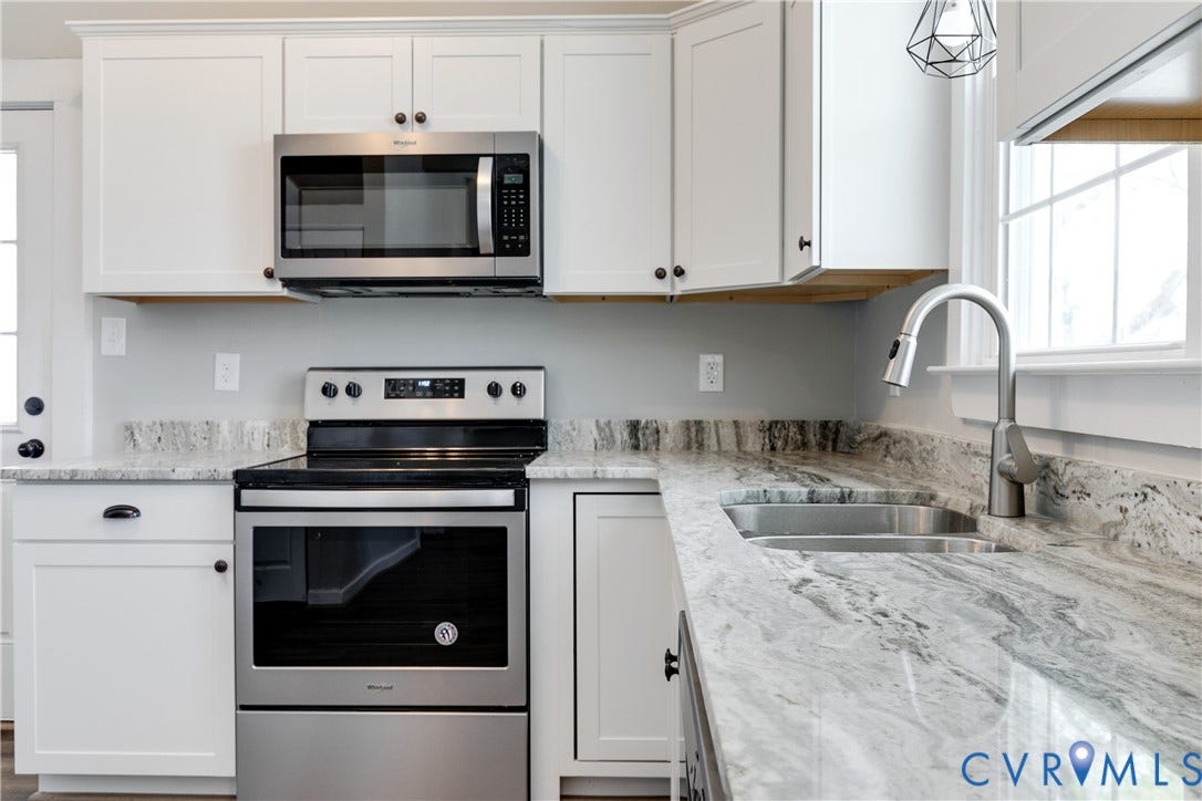 620 Chimborazo Boulevard, Church Hill, Richmond, VA 23223 Kitchen featuring white shaker-style cabinetry, natural stone countertops, stainless steel appliances, a dual-basin undermount sink, and a high-arch pull-down faucet