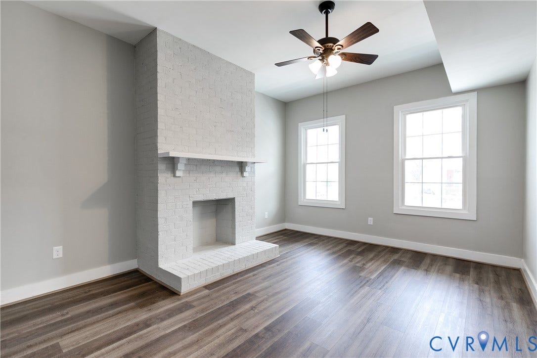 620 Chimborazo Boulevard, Church Hill, Richmond, VA 23223 Painted brick fireplace with a mantel, wood-finish flooring, two multi-pane windows, and a ceiling fan with light fixture