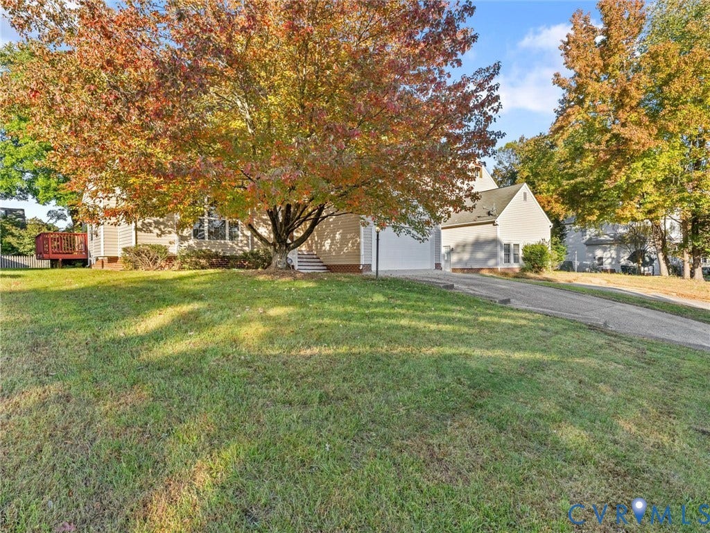 9520 Willow Ridge Drive, Glen Allen, VA 23060 Exterior featuring light-colored siding, attached garage, paved driveway, elevated wooden deck, and mature deciduous trees