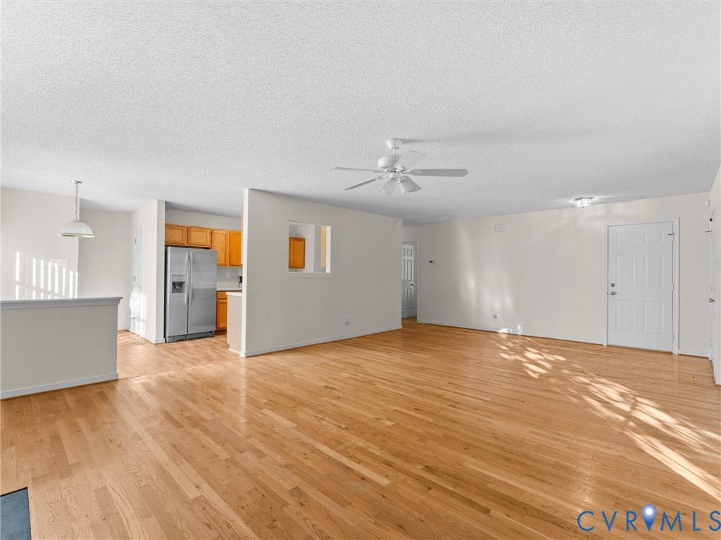 9520 Willow Ridge Drive, Glen Allen, VA 23060 Open-concept interior featuring wood-finish flooring, a pass-through wall cutout, a ceiling fan, and built-in cabinetry