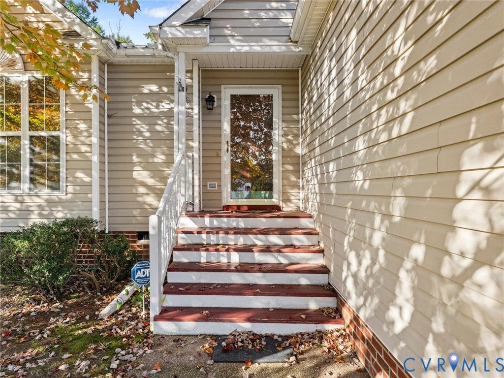 9520 Willow Ridge Drive, Glen Allen, VA 23060 Exterior entrance featuring light-toned horizontal siding, brick masonry base, white railing, and multi-step wooden staircase