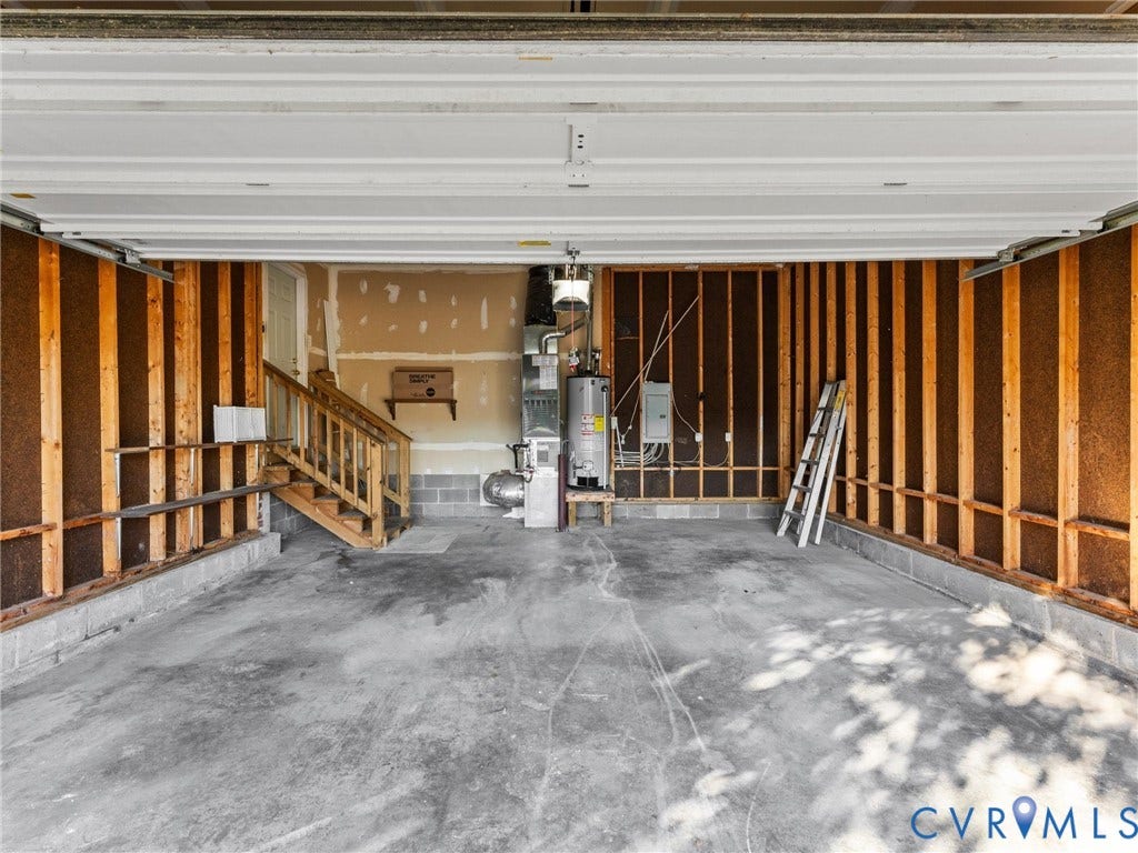 9520 Willow Ridge Drive, Glen Allen, VA 23060 Garage featuring exposed wood framing, concrete flooring, overhead sectional door, water heater, and mechanical furnace system