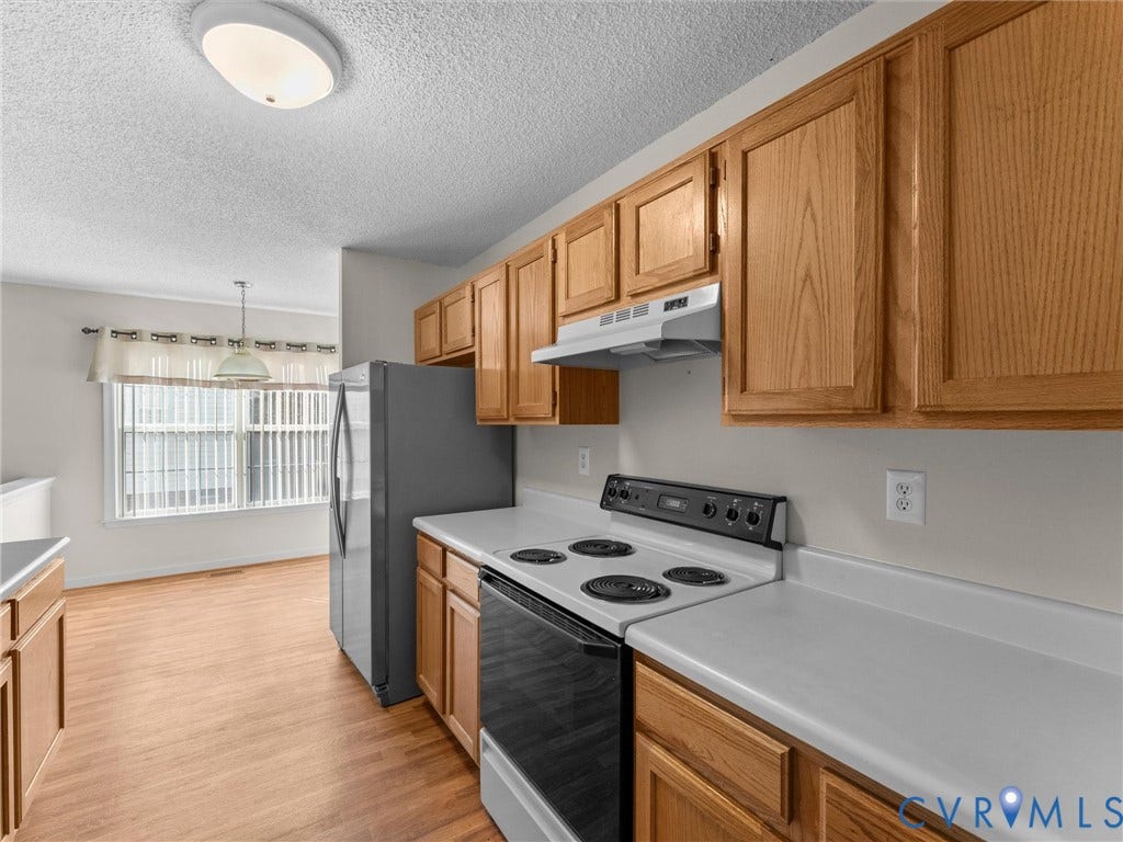 9520 Willow Ridge Drive, Glen Allen, VA 23060 Kitchen featuring wood cabinetry, solid surface countertops, a stainless steel refrigerator, and an electric range with an integrated ventilation hood