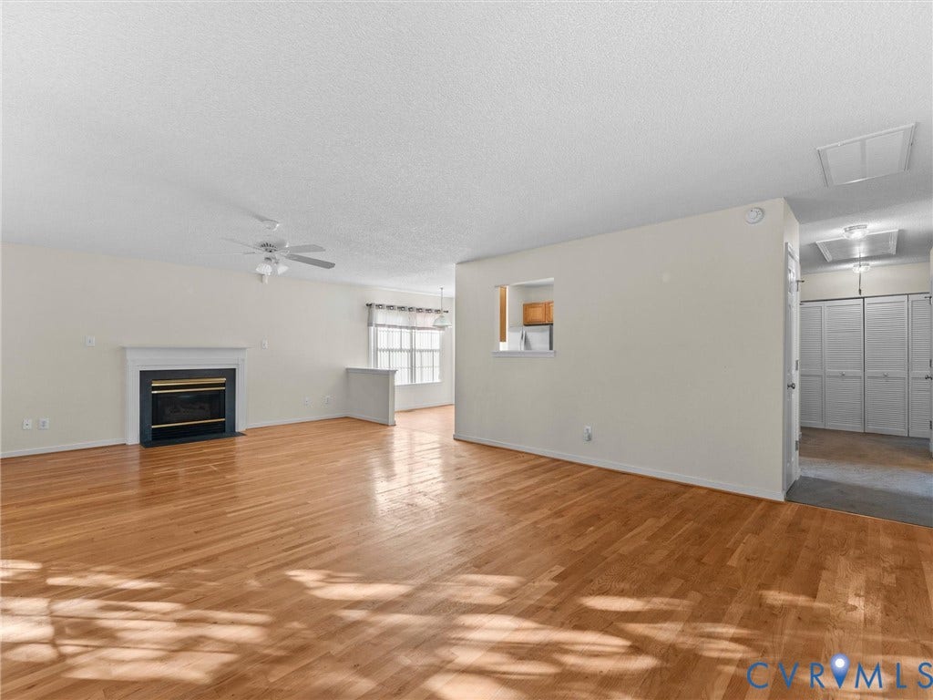 9520 Willow Ridge Drive, Glen Allen, VA 23060 Living area featuring wood-finish flooring, a fireplace with a mantel, a ceiling fan, and multi-panel louvered closet doors