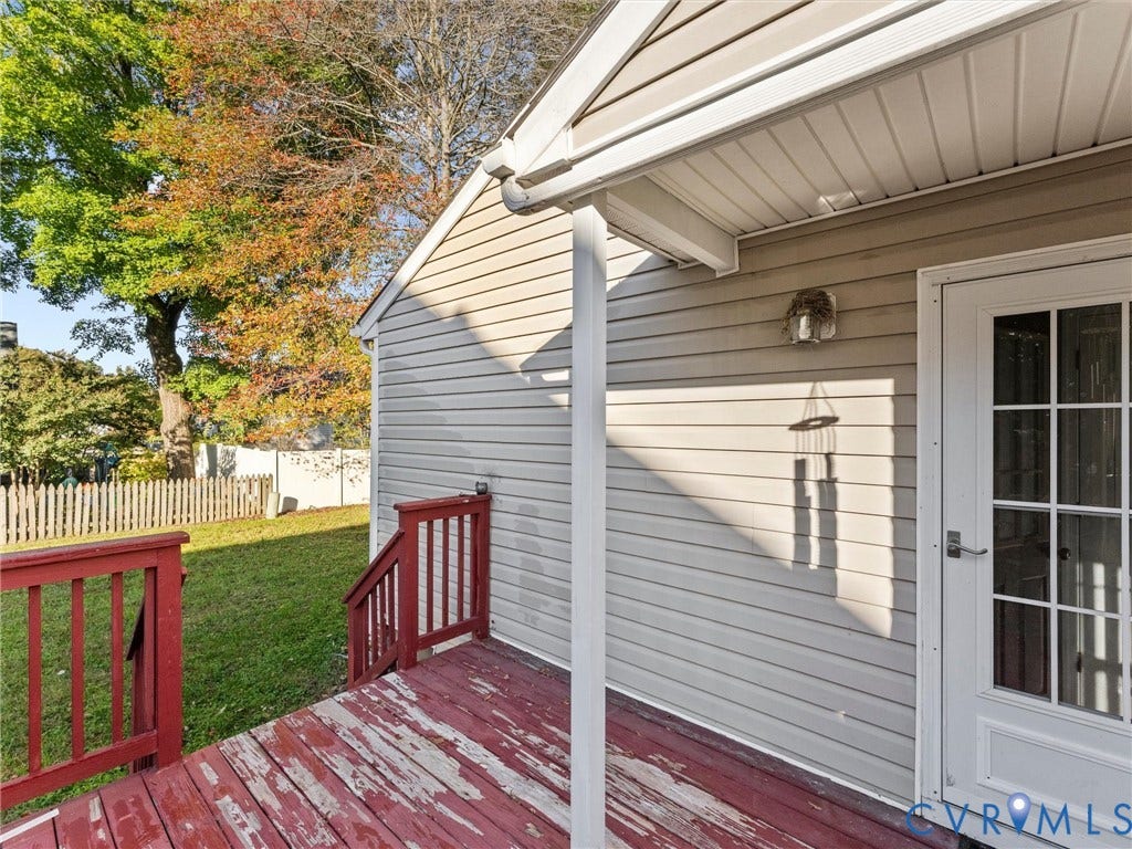 9520 Willow Ridge Drive, Glen Allen, VA 23060 Exterior deck with red-painted wood planks and railings, light-colored horizontal siding, and white-trimmed glass-pane door
