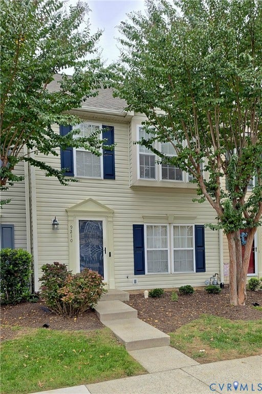9210 Silverbush Drive, Henrico, VA 23228 Multi-story residence featuring light-colored horizontal siding, dual-hung windows with decorative shutters, and a covered entry with a pediment