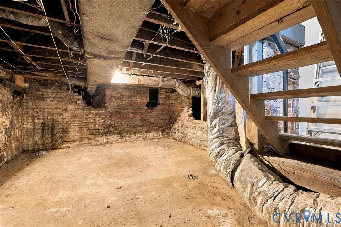 1911 3rd Avenue, Richmond, VA 23222 Unfinished lower level featuring exposed wooden ceiling joists, brick foundation walls, and an open wooden staircase