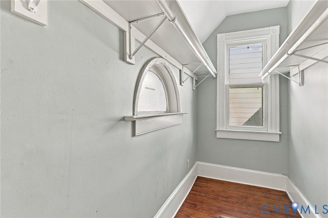1911 3rd Avenue, Richmond, VA 23222 Storage area featuring wood-finish flooring, a double-hung window, a decorative arched window, and white built-in shelving